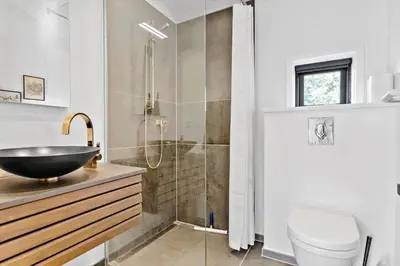 a bathroom with a sink and a glass shower at LK1946-Lokken-Kringelbaekvej-5 in Løkken