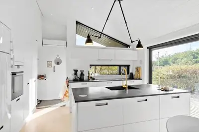 a kitchen with white cabinets and a sink and a window at LK1946-Lokken-Kringelbaekvej-5 in Løkken
