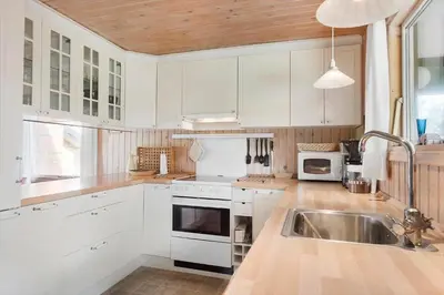 a kitchen with white cabinets and a sink at LK2071-Lokken-Marensvej-3 in Løkken