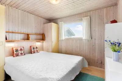 a bedroom with a white bed and a window at LK2071-Lokken-Marensvej-3 in Løkken