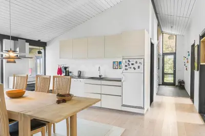 a kitchen with a wooden table and white appliances at LK2007-Lokken-Stellavej-11 in Løkken