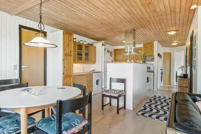 a kitchen and living room with a table and chairs at LK561-Lokken-Lisbethsvej-1 in Løkken