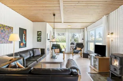 a living room with a leather couch and a tv at LK561-Lokken-Lisbethsvej-1 in Løkken