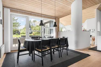 a dining room with a black table and chairs at LK310-Lokken-Magdalenevej-39 in Løkken