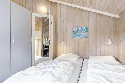 two beds in a room with wooden walls at LK1641-Lokken-Karinavej-3 in Løkken