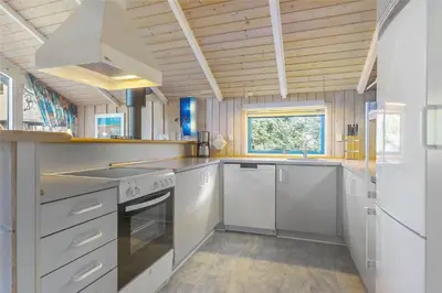 a kitchen with white appliances and a wooden ceiling at LK1641-Lokken-Karinavej-3 in Løkken