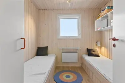 a small room with two beds and a window at LK1793-Lokken-Jettesvej-3 in Løkken