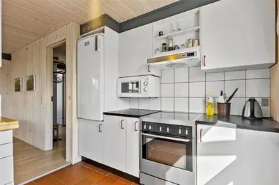 a kitchen with white cabinets and a stainless steel oven at LK1793-Lokken-Jettesvej-3 in Løkken