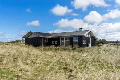 a black house on a hill in a field at LK1793-Lokken-Jettesvej-3 in Løkken