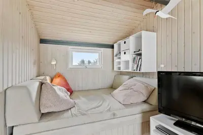 a small living room with a couch and a tv at LK1793-Lokken-Jettesvej-3 in Løkken