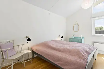 a bedroom with a bed and a chair and a window at LK1790-Lokken-Gronhoj-Strandvej-174 in Løkken