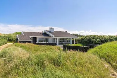 a house on the top of a grassy hill at LK1790-Lokken-Gronhoj-Strandvej-174 in Løkken