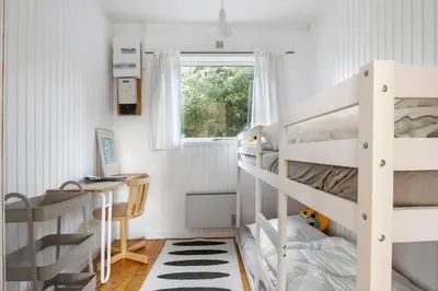 a small bedroom with two bunk beds and a desk at LK2115-Lokken-Marthasvej-7 in Løkken