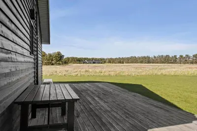 a wooden bench sitting on the porch of a house at LK167-Lokken-Kringelbaekvej-43 in Løkken