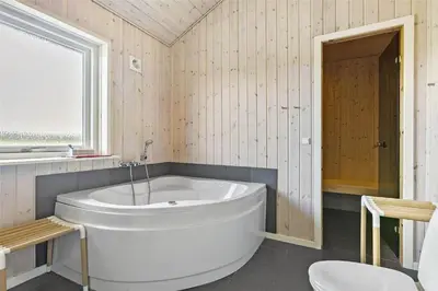 a white bath tub in a bathroom with a window at LK167-Lokken-Kringelbaekvej-43 in Løkken
