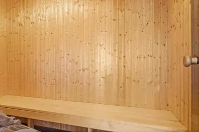 a sauna with wooden walls and a wooden bench at LK167-Lokken-Kringelbaekvej-43 in Løkken