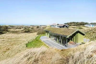 a house with a grass roof on a beach at LK1985-Lokken-Monasvej-24 in Løkken
