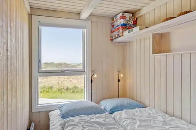 a small bedroom with a bed and a window at LK1985-Lokken-Monasvej-24 in Løkken