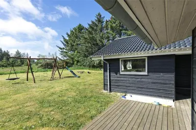 a house with a playground in a field at LK902-Lokken-Mievej-42 in Løkken