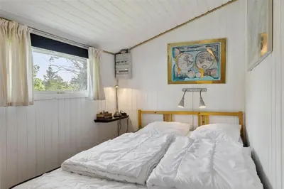 a white bed in a room with a window at LK564-Lokken-Piasvej-17 in Løkken
