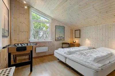 a bedroom with a bed and a desk and a window at LK564-Lokken-Piasvej-17 in Løkken