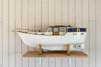 a small white boat sitting on a wooden shelf at LK528-Lokken-Rosavej-5 in Løkken