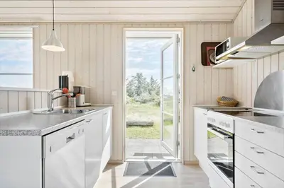 a white kitchen with a sink and a window at LK528-Lokken-Rosavej-5 in Løkken