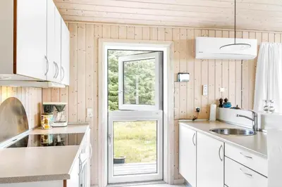 a kitchen with white cabinets and a window at LK248-Lokken-Sinnesvej-43 in Løkken