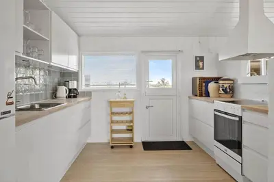 a white kitchen with a sink and a window at LK1609-Lokken-Kettrup-Bjerge-Vej-82 in Løkken