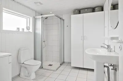 a white bathroom with a toilet and a sink at LK1609-Lokken-Kettrup-Bjerge-Vej-82 in Løkken