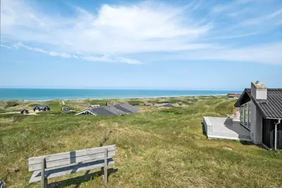 a bench sitting on a grassy hill next to a house at LK1609-Lokken-Kettrup-Bjerge-Vej-82 in Løkken