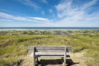 a wooden bench sitting on top of a hill overlooking the ocean at LK1609-Lokken-Kettrup-Bjerge-Vej-82 in Løkken