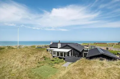 a house on a hill with the ocean in the background at LK1609-Lokken-Kettrup-Bjerge-Vej-82 in Løkken