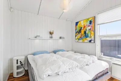 a bedroom with a large bed with white sheets at LK329-Lokken-Marensvej-12 in Løkken