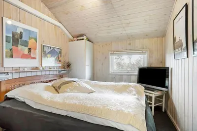 a bedroom with a bed and a desk with a computer at LK847-Lokken-Odavej-59 in Løkken