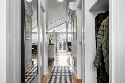 a hallway with white walls and a blue and white rug at LK847-Lokken-Odavej-59 in Løkken