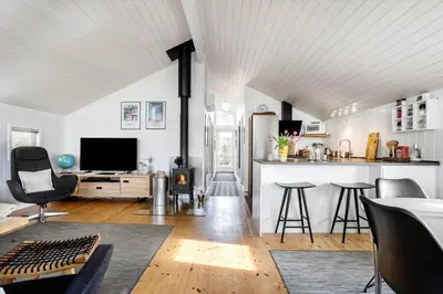 a living room with a table and chairs and a television at LK847-Lokken-Odavej-59 in Løkken