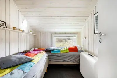 a room with two beds with colorful pillows in it at LK847-Lokken-Odavej-59 in Løkken