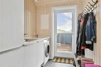 a kitchen with a washing machine and a door to a balcony at LK1280-Lokken-Kettrup-Bjerge-Vej-98 in Løkken