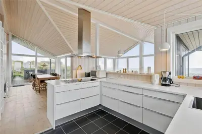 a kitchen with white cabinets and a dining room at LK1280-Lokken-Kettrup-Bjerge-Vej-98 in Løkken