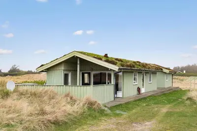 a green house with a grass roof on a field at LK784-Lokken-Sinnesvej-7 in Løkken