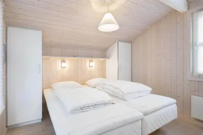 two beds in a room with wooden walls at LK1179-Lokken-Normasvej-6 in Løkken