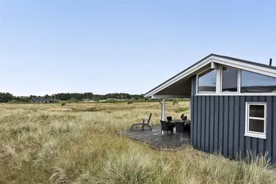 a small house with a table in a field at LK1179-Lokken-Normasvej-6 in Løkken