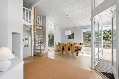 a dining room and living room with a table and chairs at LK1716-Lokken-Marthasvej-28 in Løkken