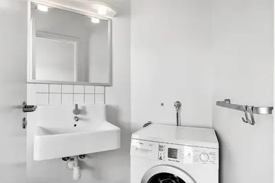 a bathroom with a washing machine and a sink at LK1716-Lokken-Marthasvej-28 in Løkken