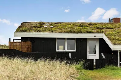 a black house with a grassy hill on top of it at LK2033-Lokken-Madsinesvej-13 in Løkken