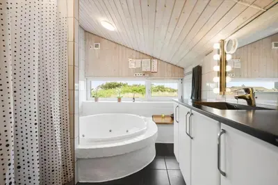 a bathroom with a white tub and a sink at LK2033-Lokken-Madsinesvej-13 in Løkken