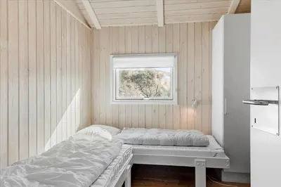 a small bedroom with a bed and a window at LK1847-Lokken-Ornegaardsvej-17 in Løkken