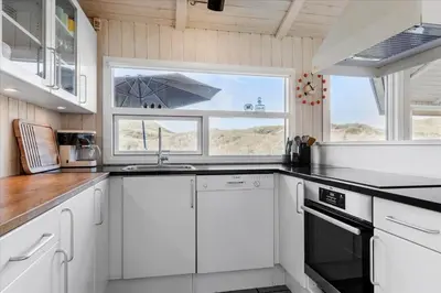 a kitchen with white cabinets and a sink and a window at LK1847-Lokken-Ornegaardsvej-17 in Løkken