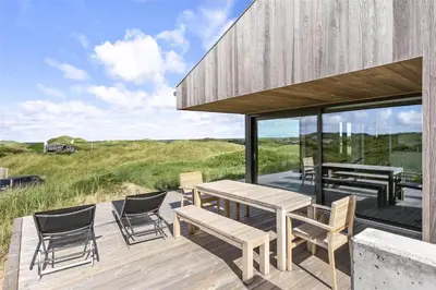 a wooden deck with a picnic table and chairs at LK1272-Lokken-Ruthsvej-17 in Løkken